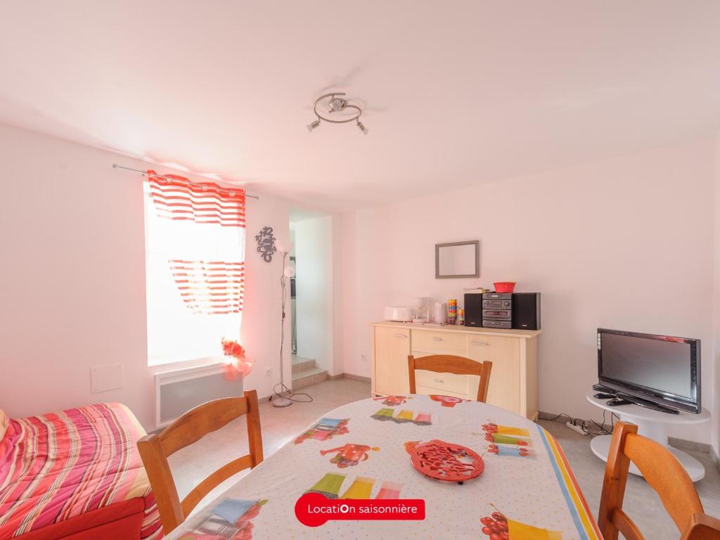 ein Wohnzimmer mit einem Tisch und einem TV in der Unterkunft Appartement Châtelaillon-Plage, 2 pièces, 4 personnes - FR-1-535-17 in Châtelaillon-Plage