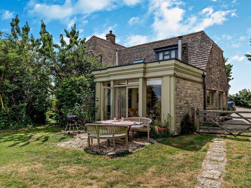 a house with a table in the yard at 1 Bed in Isle of Purbeck IC176 in Worth Matravers