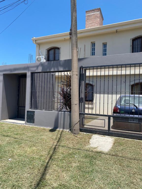 una cerca frente a una casa con un coche en ella en La escondida departamento en Salta