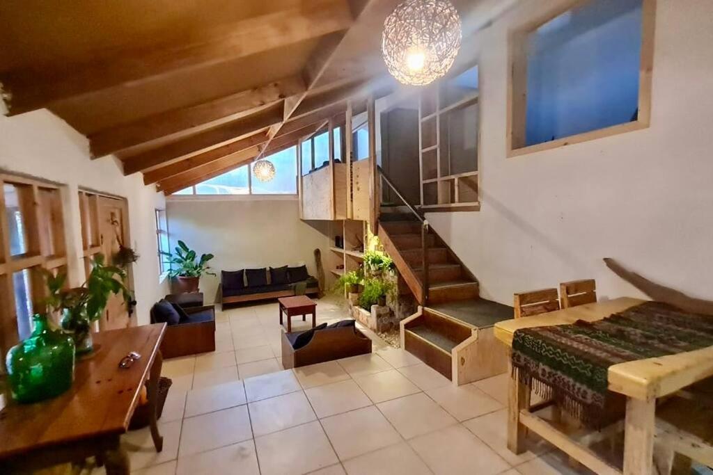 a living room with a staircase and a couch and a table at Espacio Borde Rio, Casa Pisqu in Vicuña