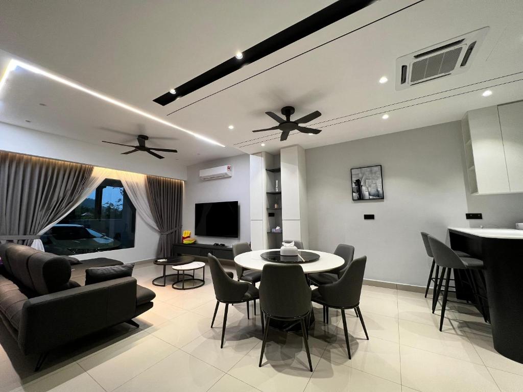 ein Wohnzimmer mit einem Tisch und Stühlen in der Unterkunft Luxe J Homestay in Taiping