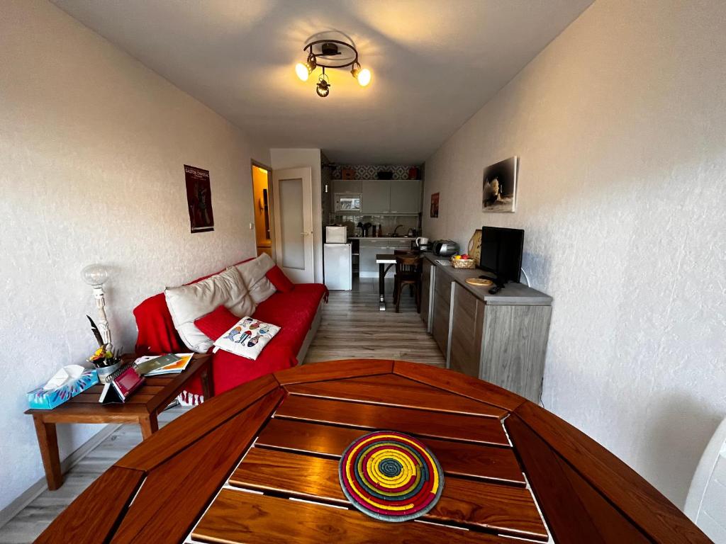 un salon avec un canapé rouge et une table dans l'établissement Appartement avec Terrasse à 50m de la Plage des Sables-d'Olonne - FR-1-197-429, à Les Sables-dʼOlonne