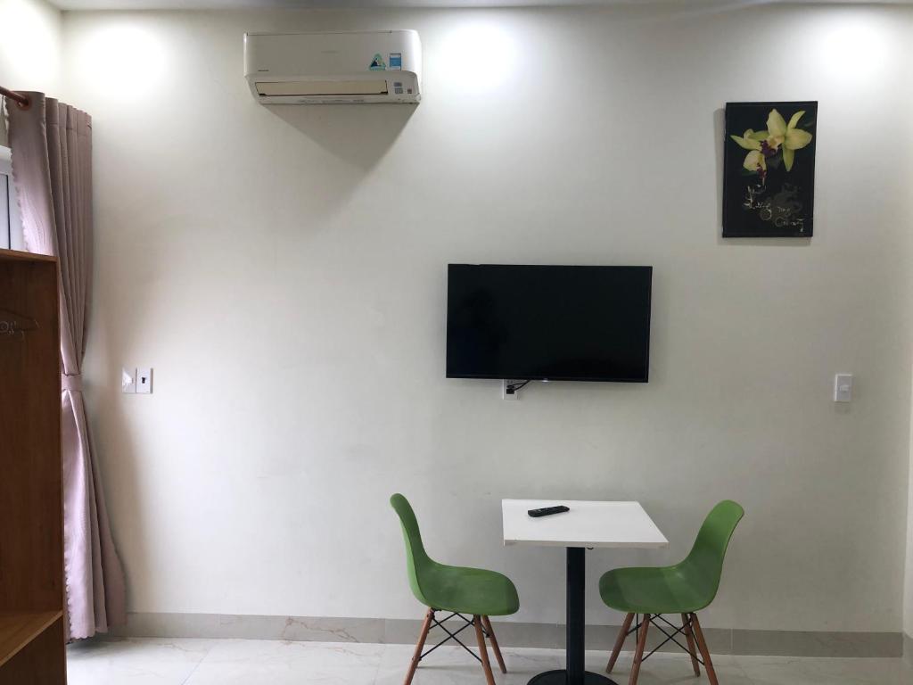 a room with two chairs and a table and a tv at Homestay 05 in Vung Tau