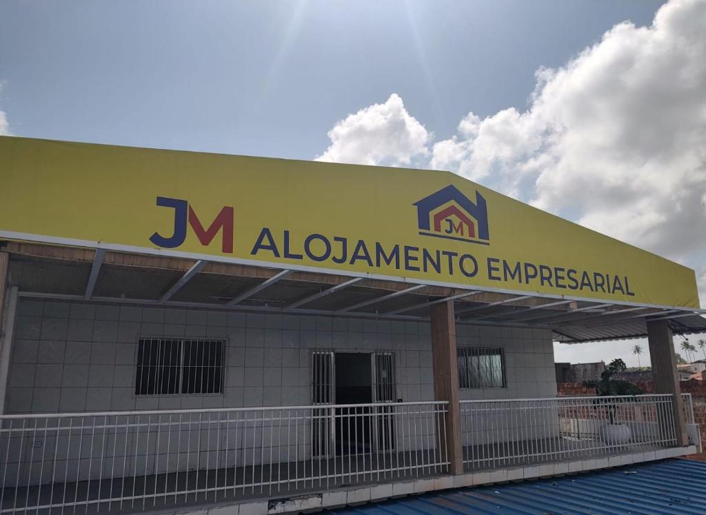 Un bâtiment avec un panneau en haut dans l'établissement JM Alojamento, à Igarassu
