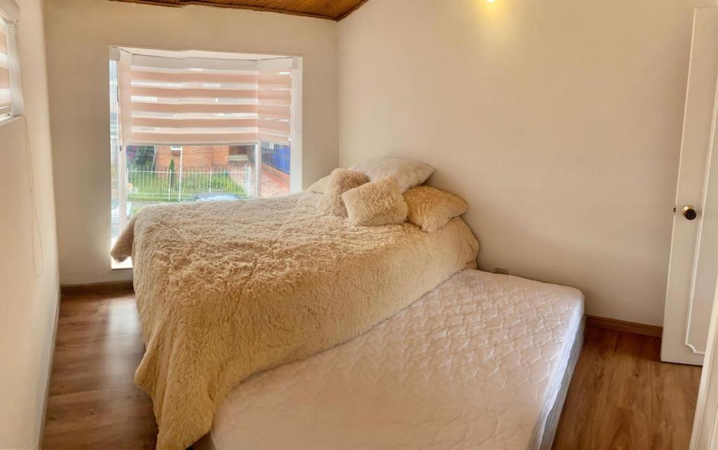 Un dormitorio con una cama con un osito de peluche. en CASA PRIVADA EN BOGOTA, en Bogotá