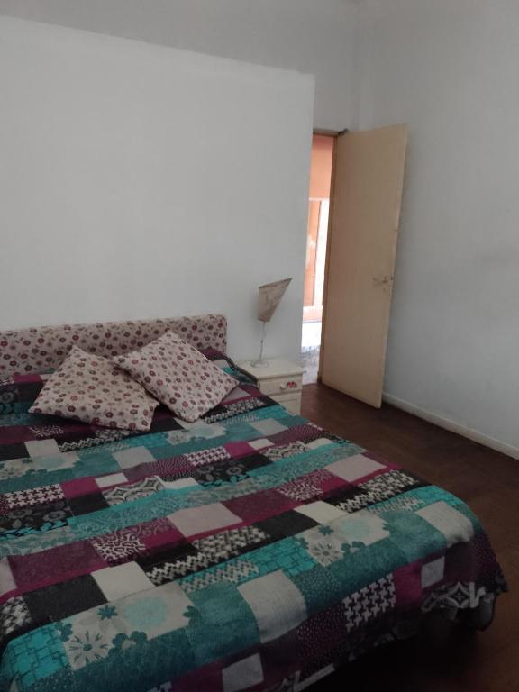 1 dormitorio con 1 cama con edredón en Hostel La Tana en Lomas de Zamora