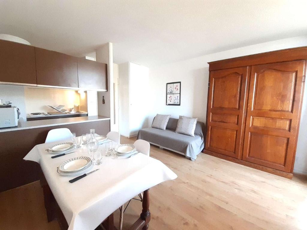 une cuisine et un salon avec une table et un canapé dans l'établissement Studio cosy 4 pers avec balcon et kitchenette au Pla d'Adet - FR-1-457-339, à Saint-Lary-Soulan
