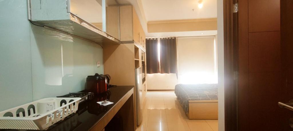 a small room with a stove and a bed at Royal Deluxe & Private Apartments - West Jakarta in Jakarta