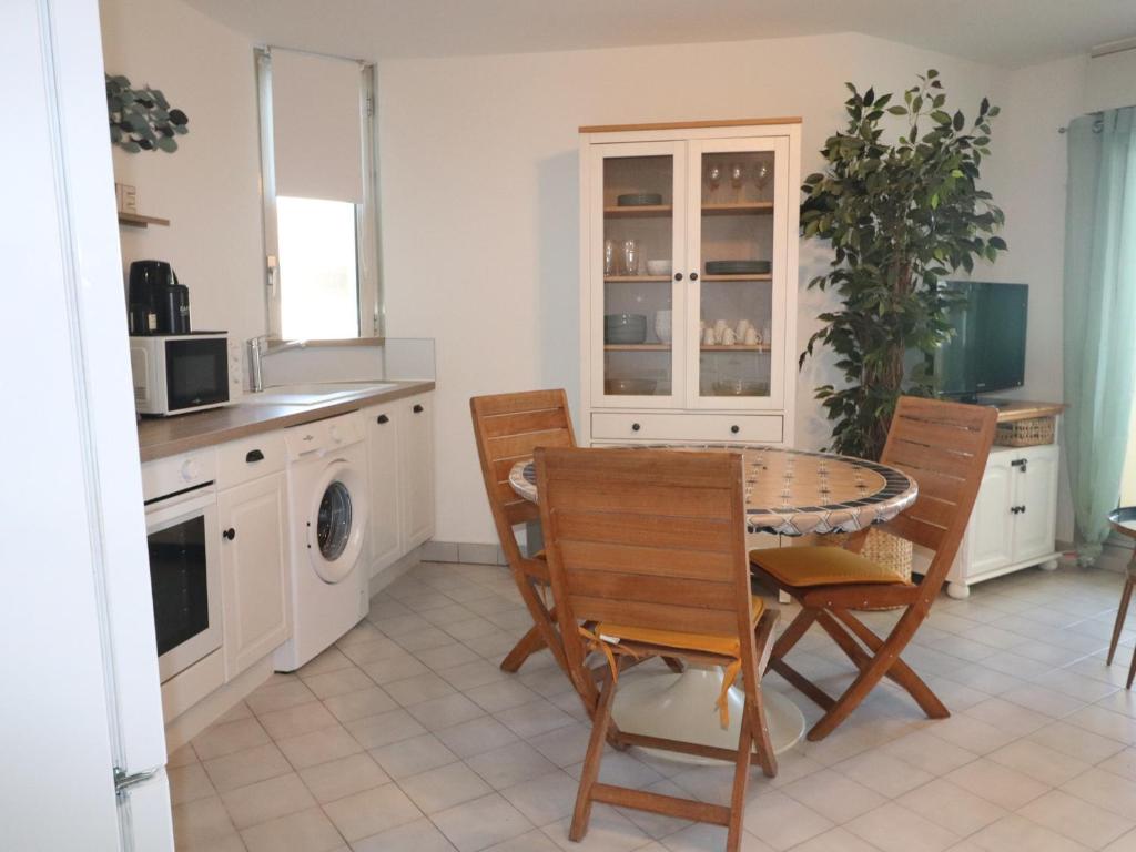 - une cuisine avec une table à manger et des chaises dans l'établissement Charmant T2 avec terrasse pour 4 pers, Sète – parking sécurisé, proche commodités - FR-1-472A-292, à Sète