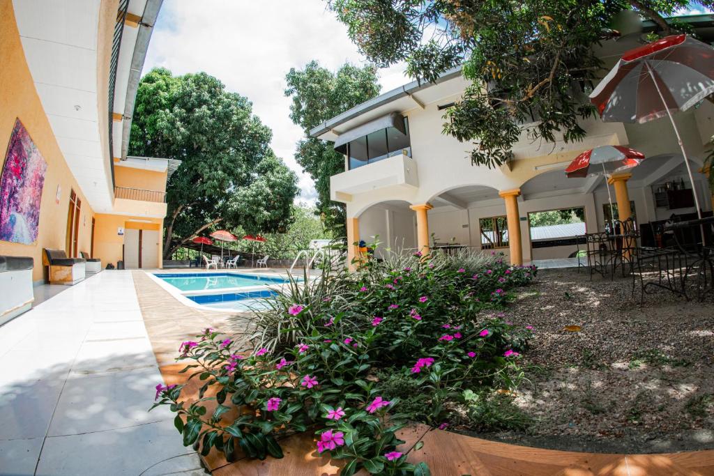 Hostal Chez Holman في San Luis: منزل به مسبح وزهور