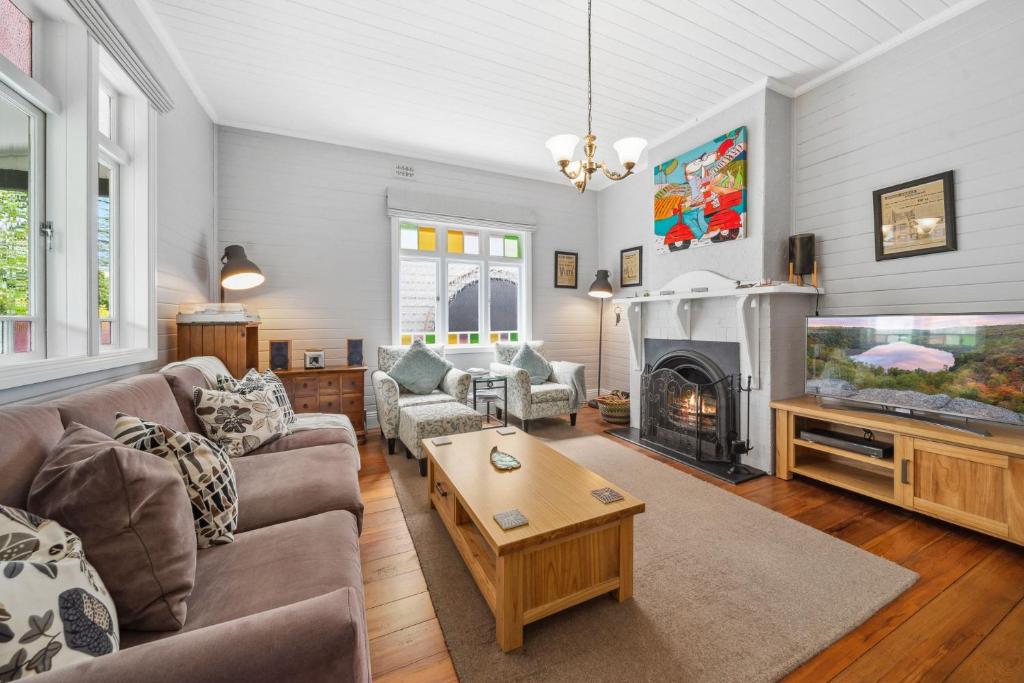 a living room with a couch and a fireplace at Trefusis Cottage in Blackheath