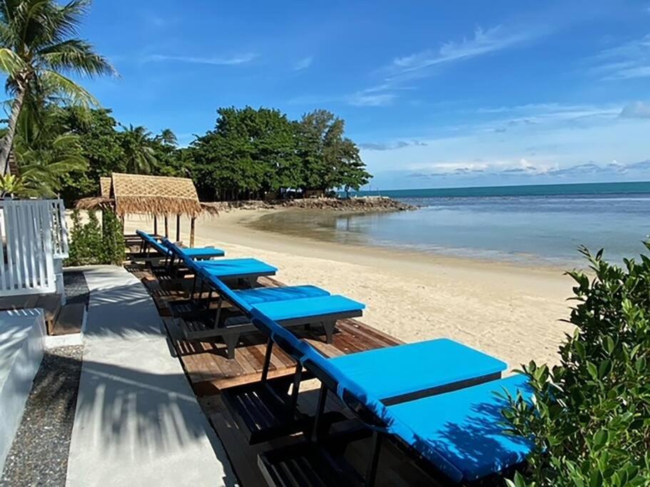 una fila di tavoli blu su una spiaggia di Nam Jai Beach Bungalow - Tropical a Nathon Bay