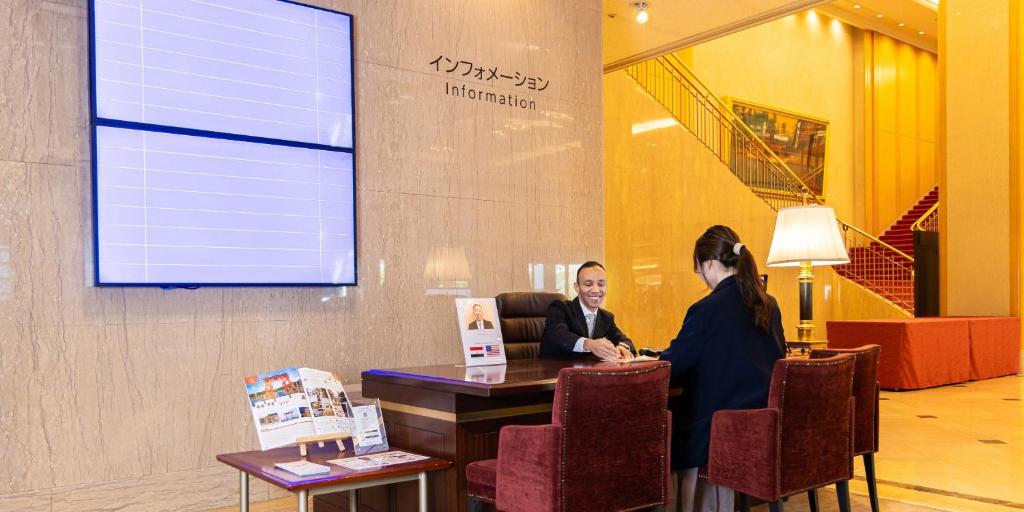 two women sitting at a table in a lobby at Rihga Royal Hotel Hiroshima in Hiroshima