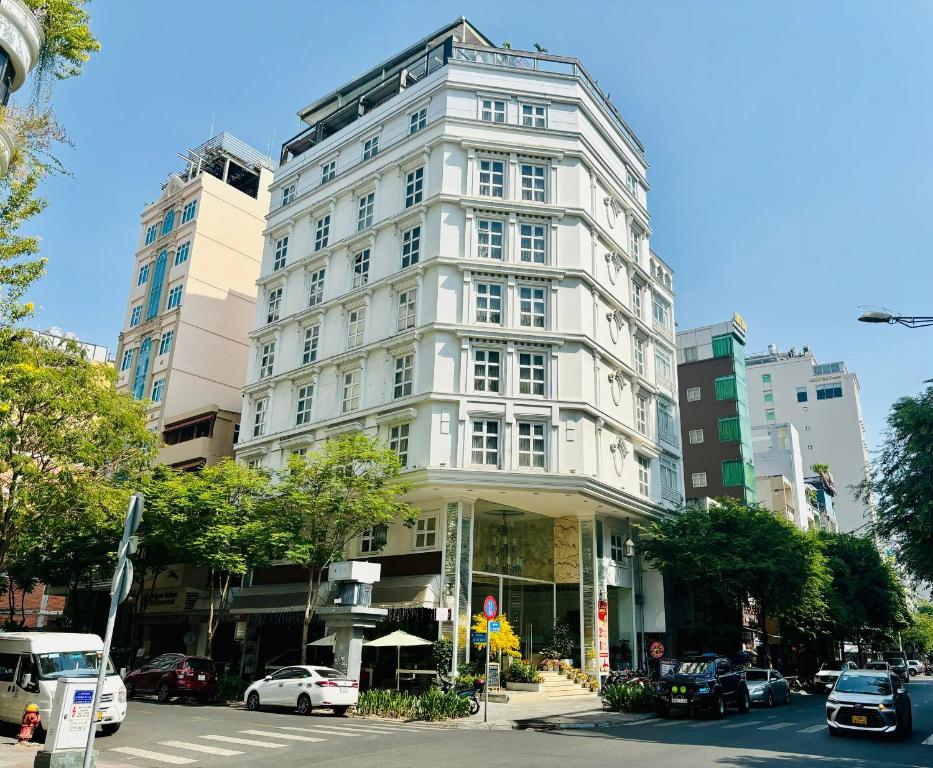 胡志明市的住宿－Corner 280，城市街道上高大的白色建筑,有汽车