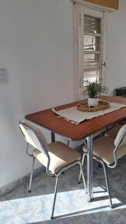 einem Esstisch mit vier Stühlen und einer Pflanze darauf in der Unterkunft Güemes in Villa María
