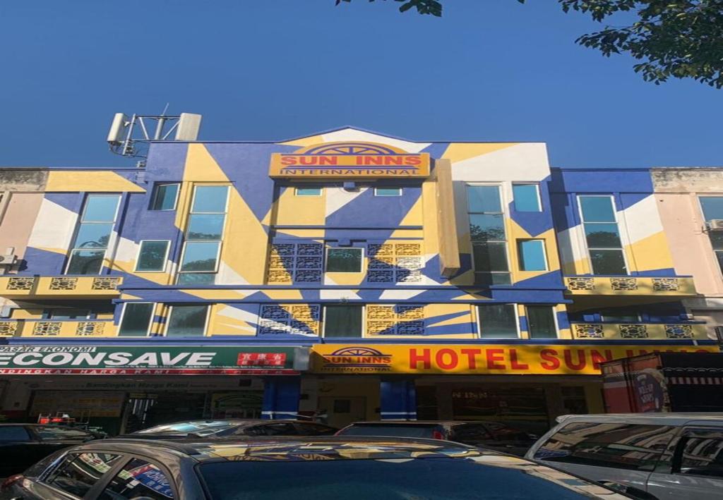 a hotel building with cars parked in front of it at Sun Inns Hotel Kepong near Hospital Sungai Buloh in Kuala Lumpur