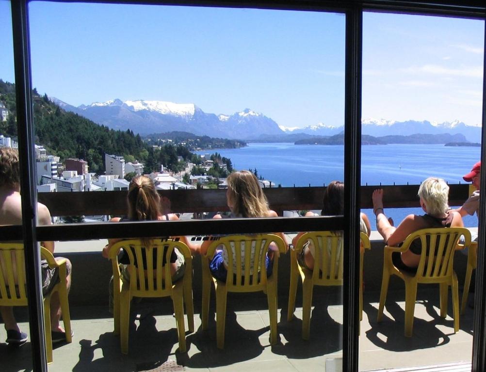 un groupe de personnes assises sur un balcon avec des chaises dans l'établissement Hospedaje Penthouse 1004, à San Carlos de Bariloche