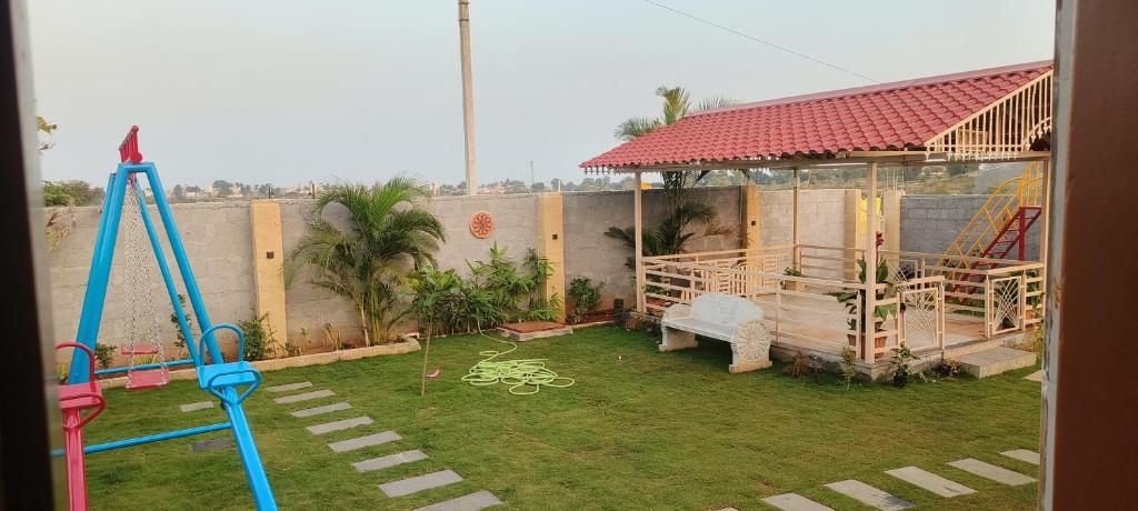 een achtertuin met een speeltuin met een schommel bij Pk Guest house in Mysore