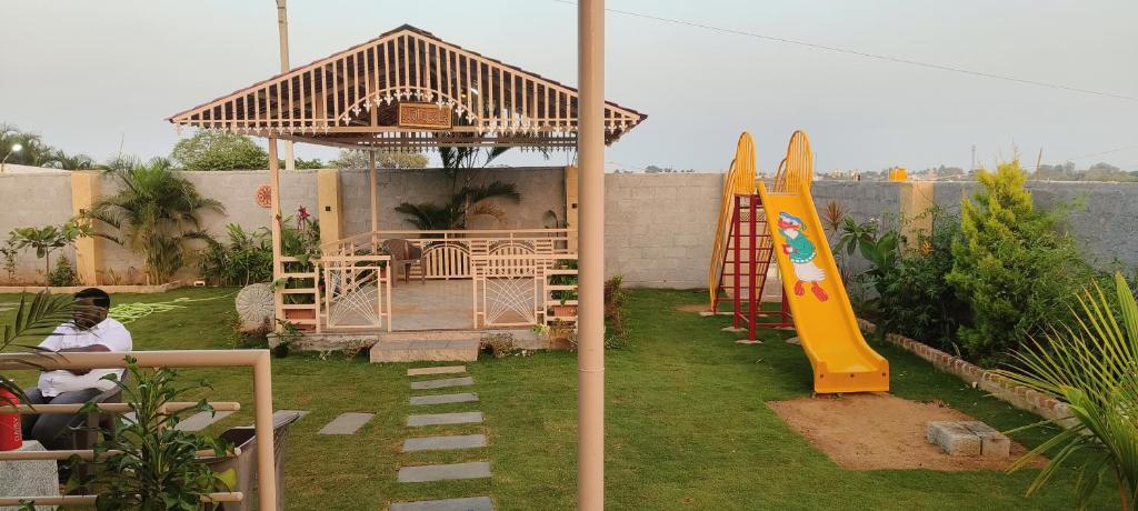 uma área de lazer com um gazebo e um parque infantil em Pk Guest house em Mysore