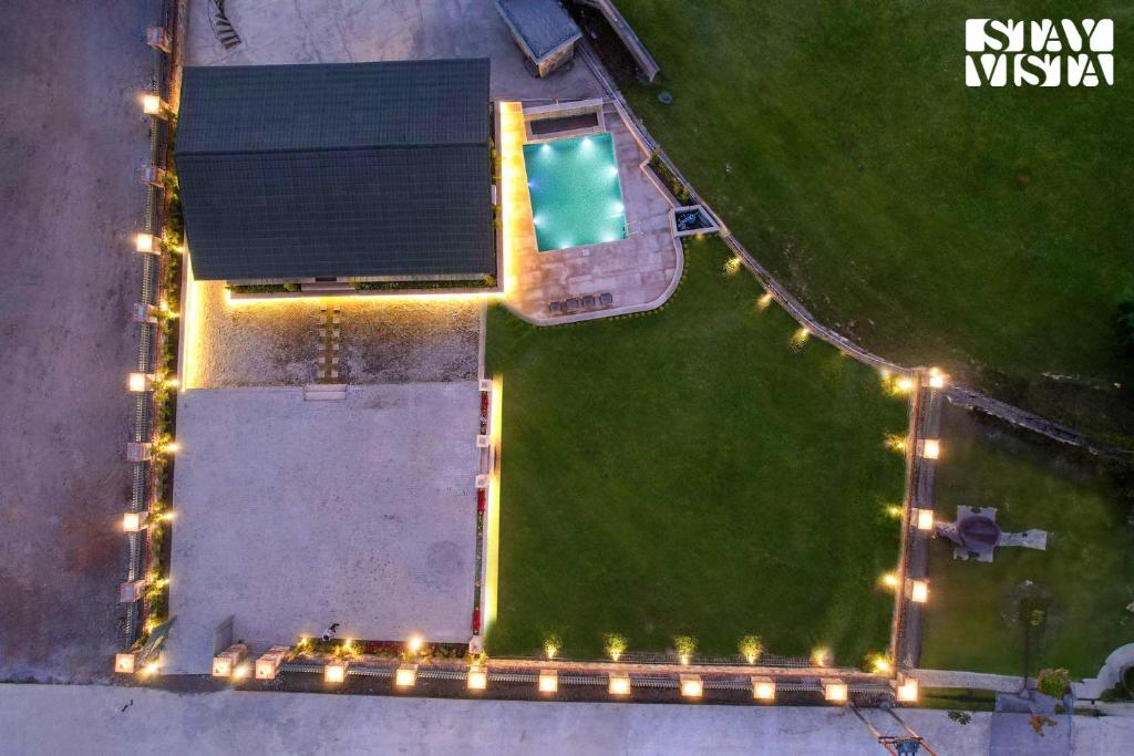 una vista aérea de una piscina con luces en StayVista at Secret Solace en Dehradun