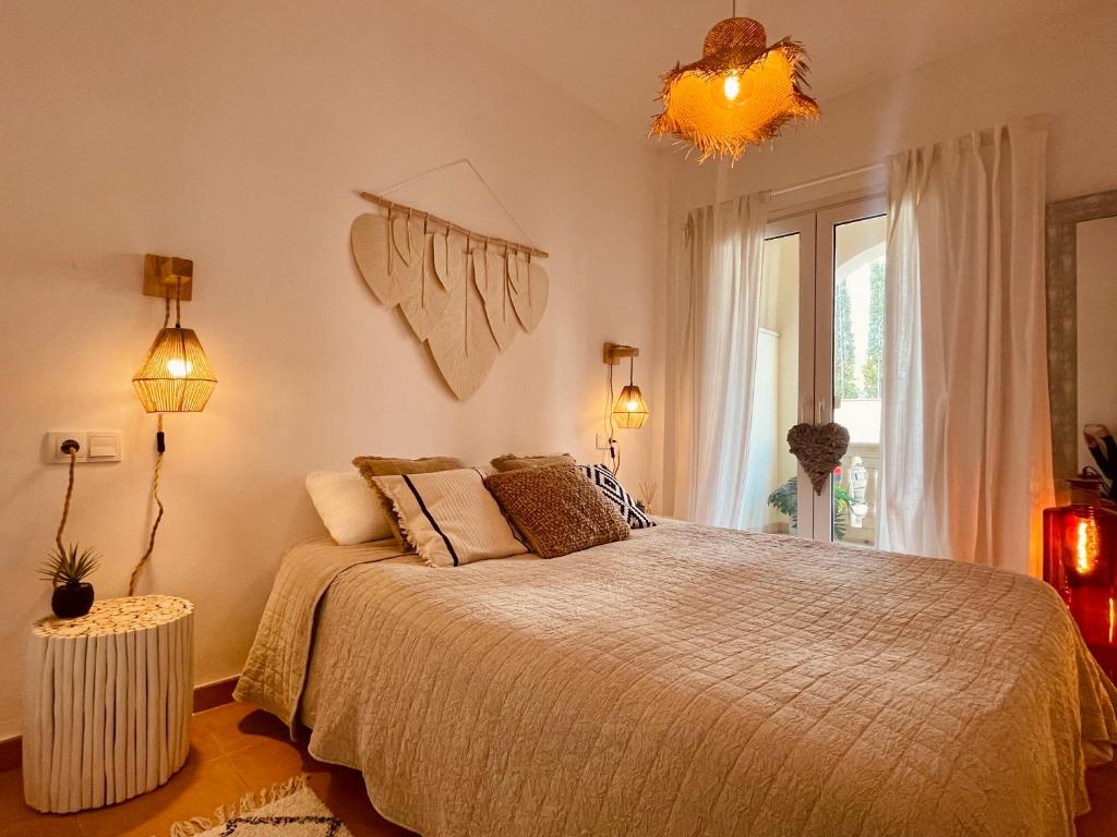 Un dormitorio con una cama grande y una ventana en Can Somni - Appartement bohème, zen et chic avec piscine, en Cala Figuera