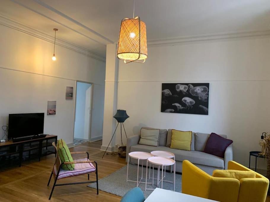 a living room with a couch and a table and chairs at MARTROI Cœur de Ville in Orléans