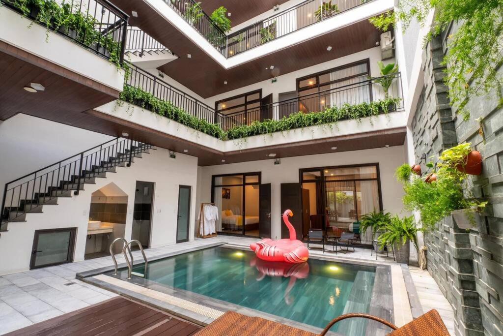 an apartment with a swimming pool with a pink flamingo in a courtyard at 9BR villa, 200m from the sea in Da Nang