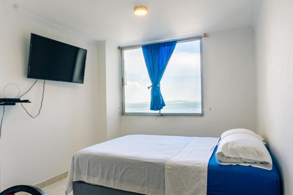 a bedroom with a bed with a window and a television at Acogedor Apartaestudio Laguito 1 Habitacion N4A in Cartagena de Indias