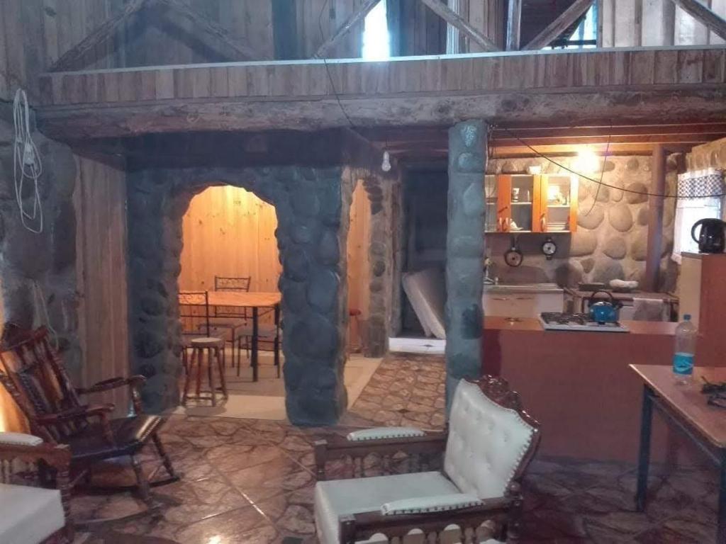 a kitchen with a stone archway with chairs and a table at Cabañas El Remanso in Linares