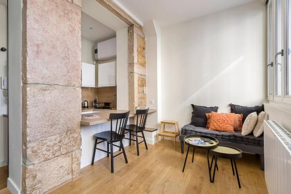 - un salon avec un canapé, une table et des chaises dans l'établissement L'Onyx - Beau studio atypique coeur Presqu'île, à Lyon