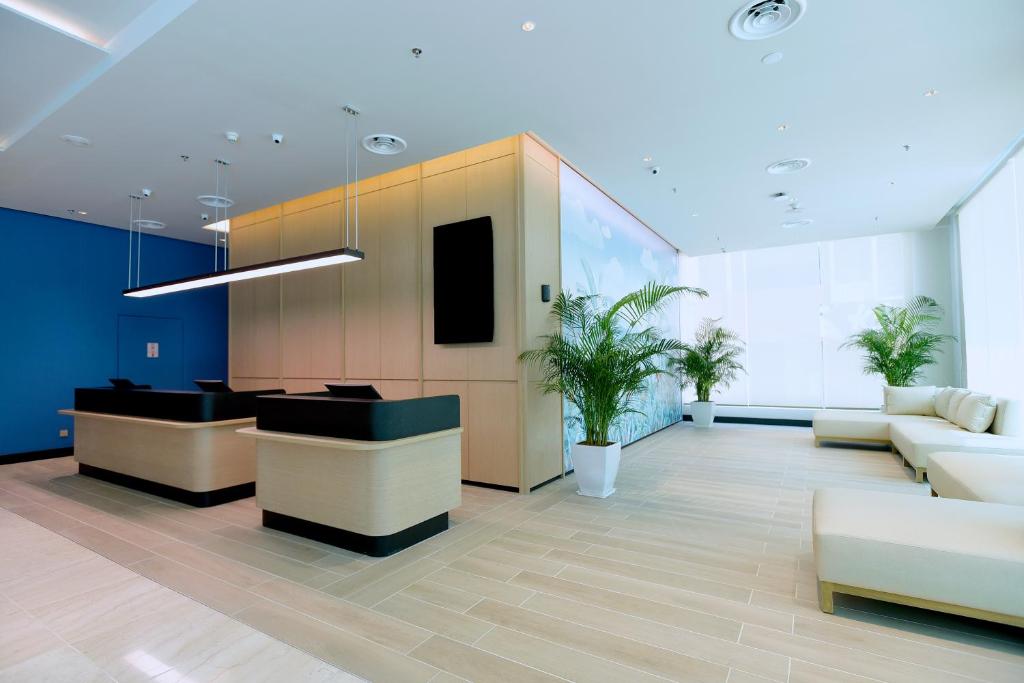 an office lobby with a reception desk and couch at Cititel Express Kota Kinabalu in Kota Kinabalu