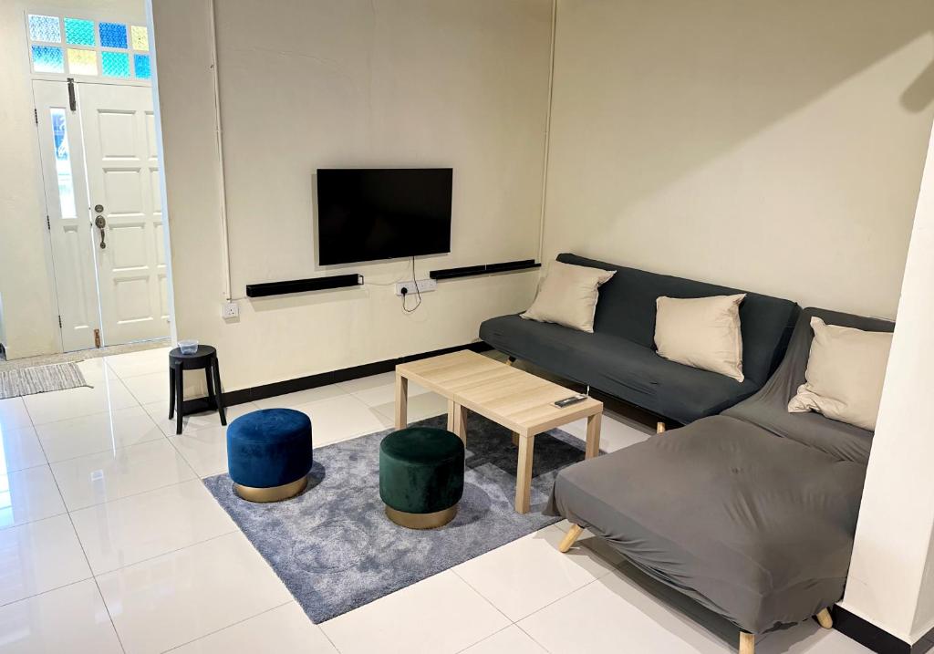 Nibong Tebal Studio Home Stay في Nibung Tebal: غرفة معيشة مع أريكة وتلفزيون