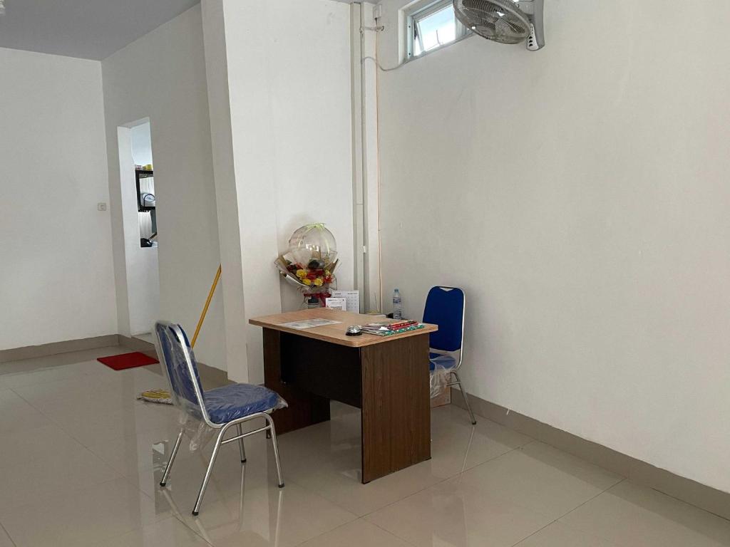 Zimmer mit einem Schreibtisch und 2 Stühlen in der Unterkunft OYO 93297 Penginapan Musafir Syariah in Pangkajene