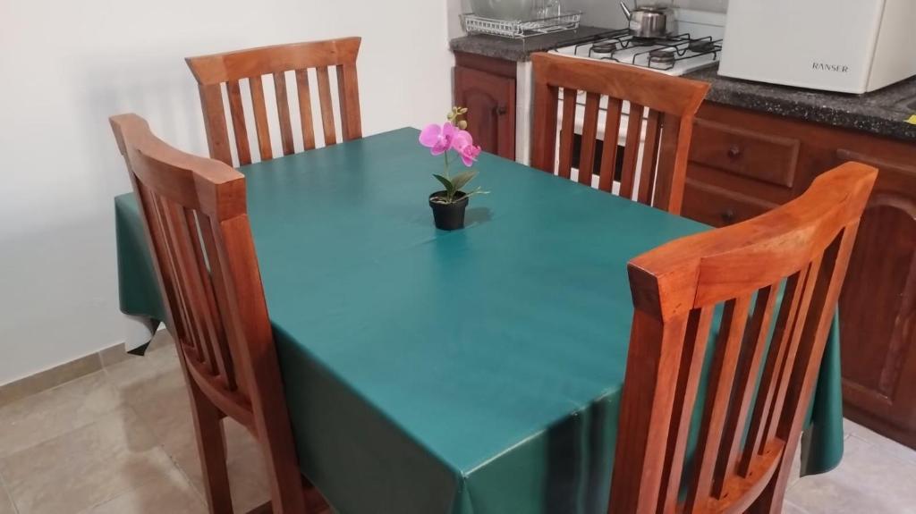 une table bleue avec un vase recouvert d'une fleur dans l'établissement Hospedaje V del Valle, à San Fernando del Valle de Catamarca