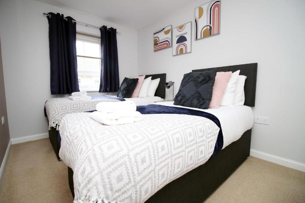 two beds sitting next to each other in a bedroom at Free Wifi | Parking Access | 3BR in Rogerstone