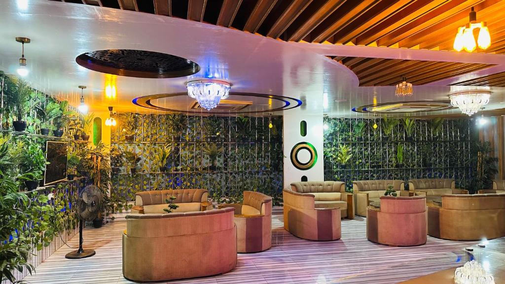 a lobby with couches and plants on the wall at Star Residence in Dhaka