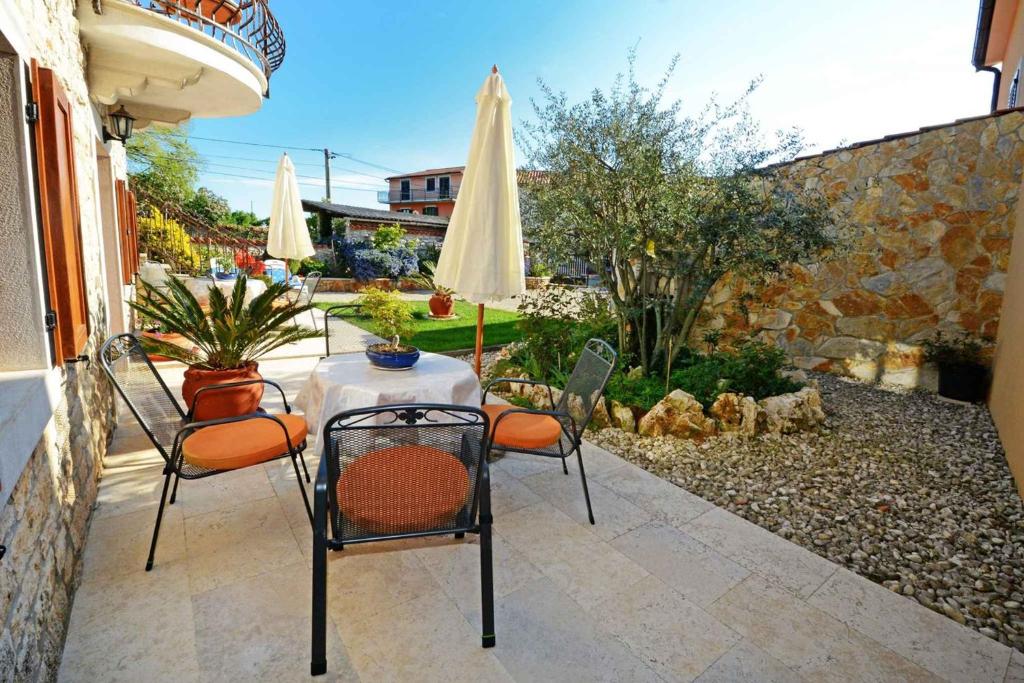 a patio with a table and chairs and an umbrella at Apartment in Baderna - Istrien 44223 in Baderna