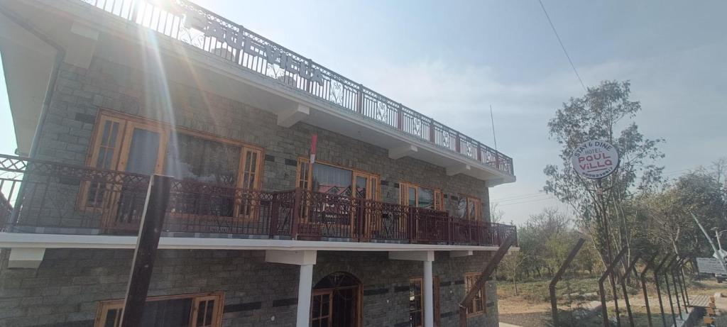 um edifício com uma varanda em cima em Hotel Paul villa em Bir