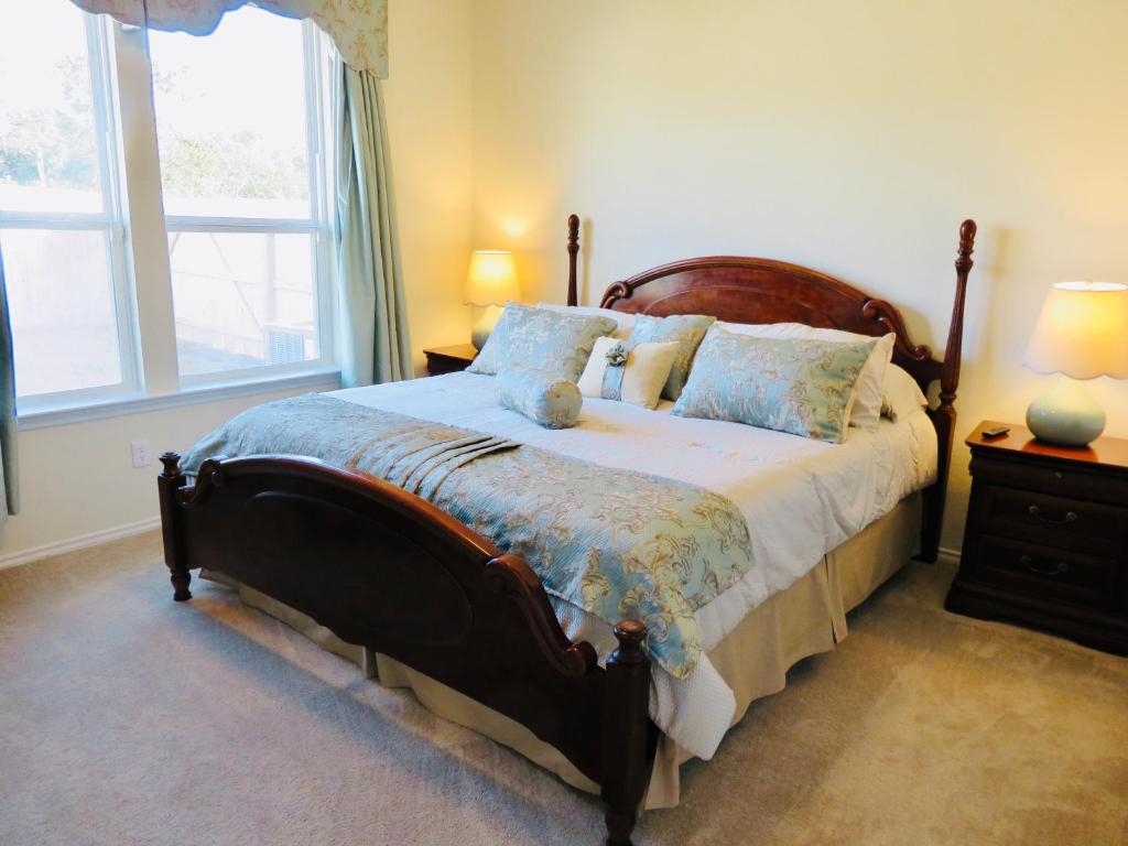 a bedroom with a large bed with blue pillows at New House family friendly near Six Flags Sea World in Helotes
