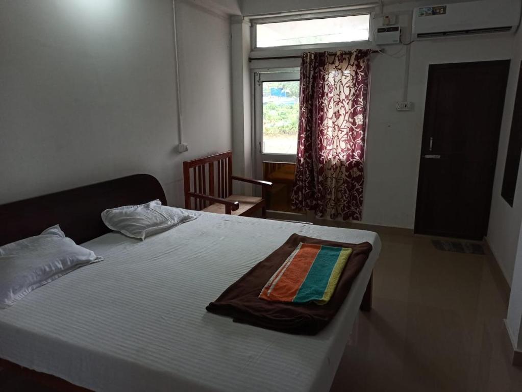 a bedroom with a large bed with a window at Punjab Residency in Port Blair