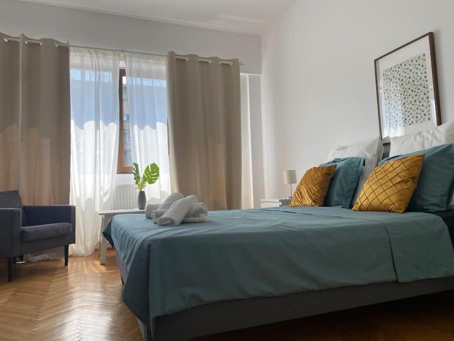 a bedroom with a bed with blue sheets and a window at 2 bedroom apartment with terrace in City Center in Bucharest