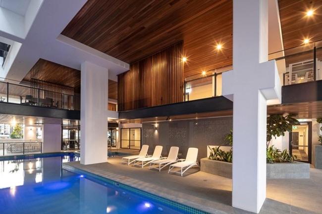 a swimming pool in a building with a house at Urban Riverside Escape at Cultural Centre Precinct in Brisbane