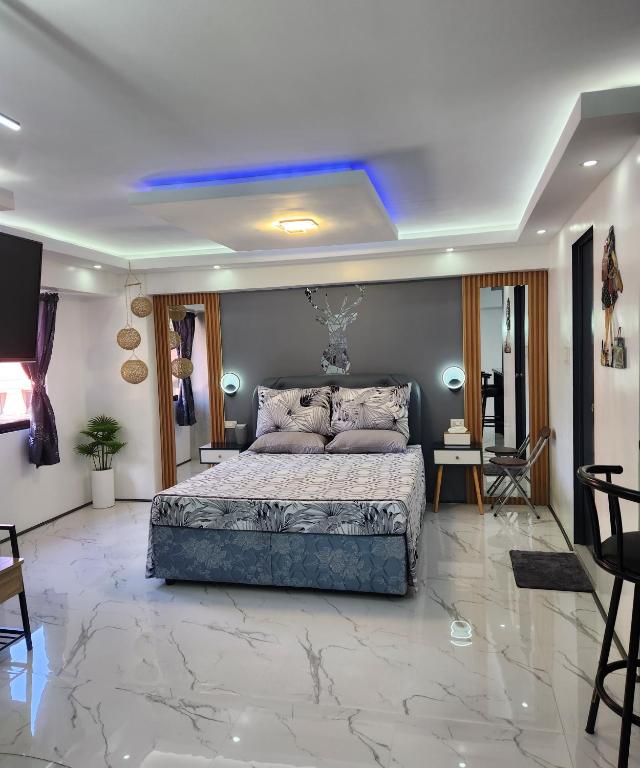 Schlafzimmer mit einem Kingsize-Bett und Marmorboden in der Unterkunft Condo Azur Suites B207 near Airport, Netflix, Stylish, Cozy with swimming pool in Lapu Lapu City