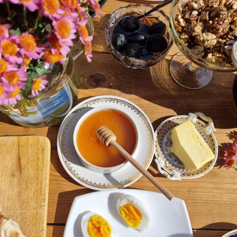 a table with a cup of tea and a bowl of cheese at Hooni_guesthouse in Odzun