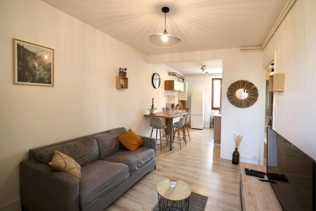 uma sala de estar com um sofá e uma mesa em « Grand Verger » - parking gratuit em Chambéry