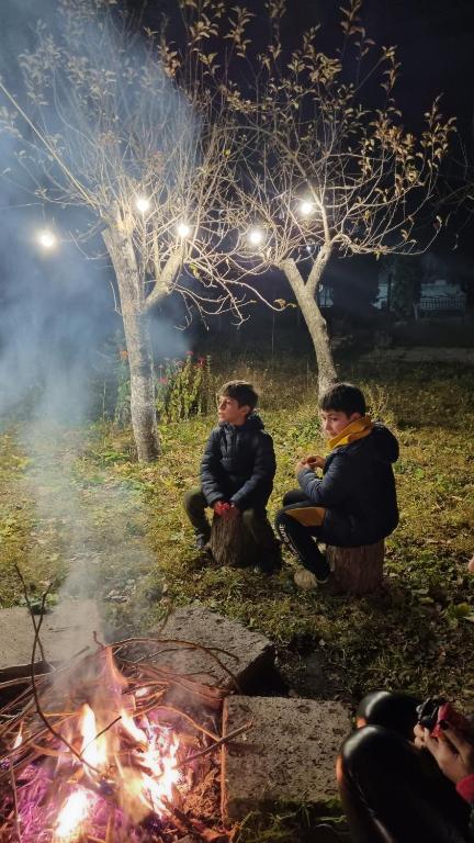 a group of people sitting around a fire at night at Hooni_guesthouse in Odzun