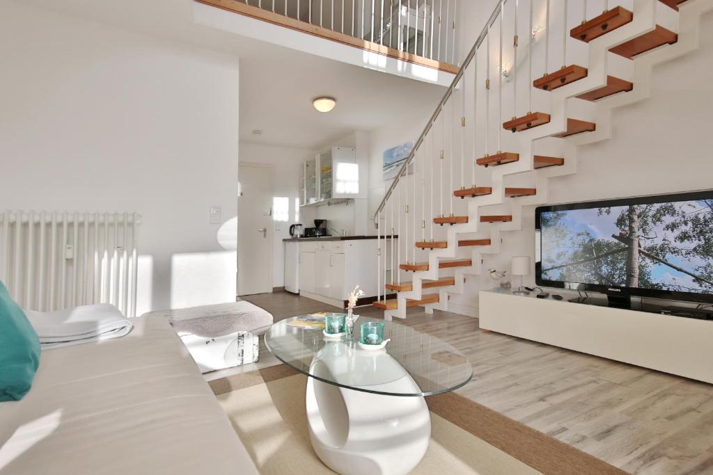 a living room with a glass table and a staircase at Haus Miramar Treffert Appartement 21 in Niendorf