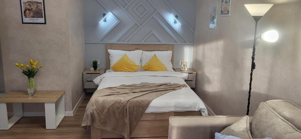 1 dormitorio con cama con almohadas amarillas y sofá en Lux Home Astana, en Öskemen