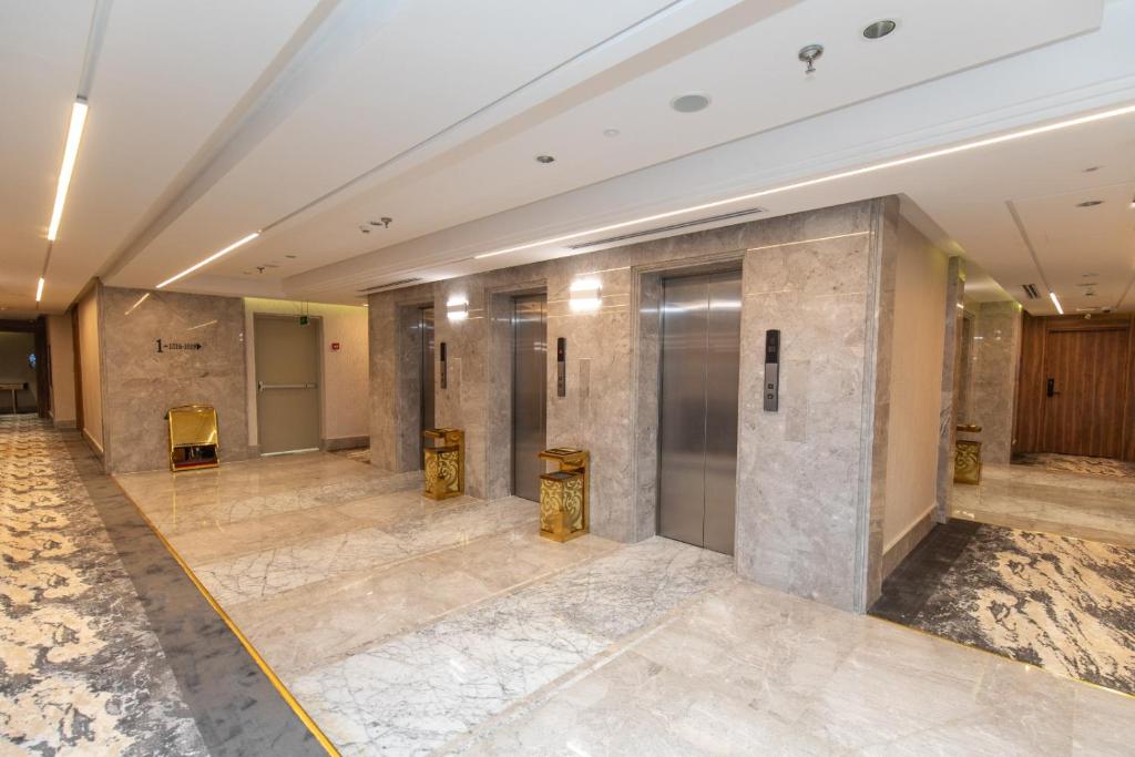 a lobby of a building with marble floors and elevators at فندق ماسة المشاعر الفندقية in Makkah