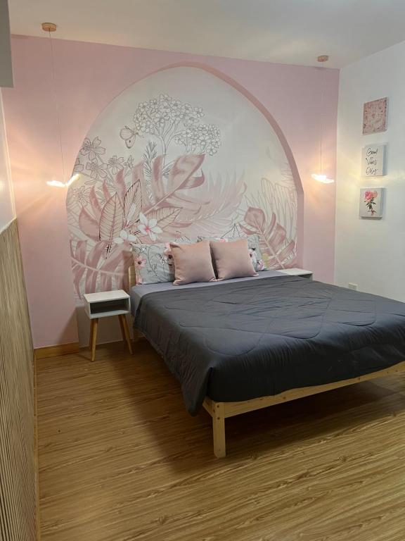a bedroom with a bed with a floral wall at CasaKulot 
